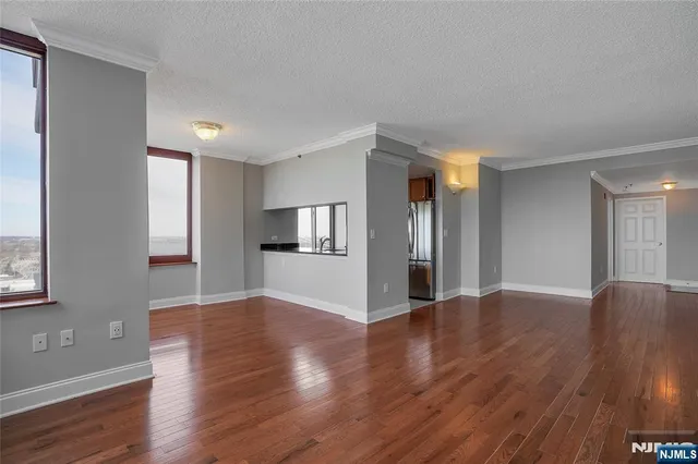 a view of empty room with wooden floor