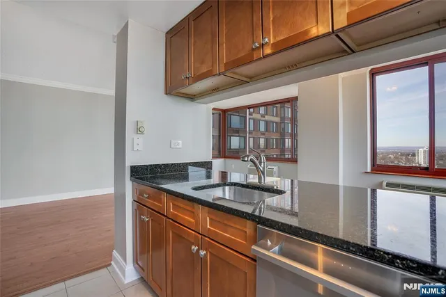 a kitchen with granite countertop stainless steel appliances a sink and cabinets