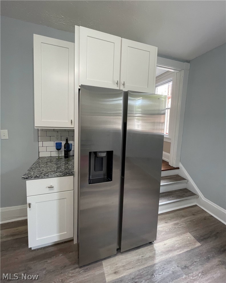 1843 Farmington Road Cleveland, OH 44112 - Photo 19 of 48 Kitchen with white cabinetry, stainless steel appliances, decorative backsplash, and luxury laminate flooring