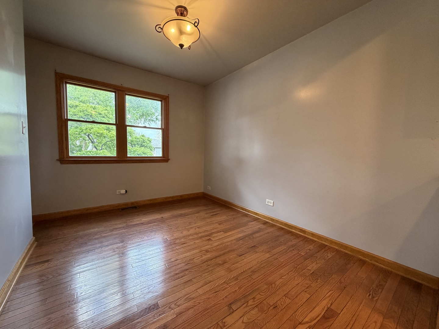 7841 45th Place Lyons, IL 60534 - Photo 13 of 23 a view of an empty room with wooden floor and a window