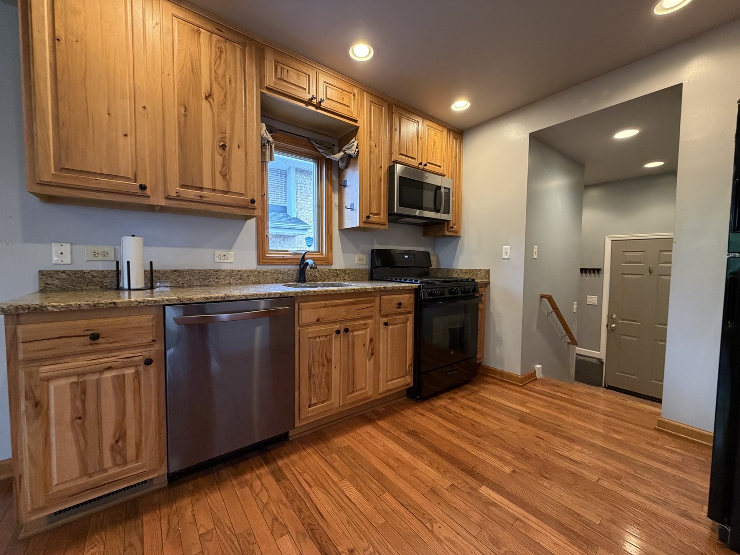 7841 45th Place Lyons, IL 60534 - Photo 14 of 23 a kitchen with stainless steel appliances granite countertop a refrigerator a sink dishwasher and wooden cabinets with wooden floor