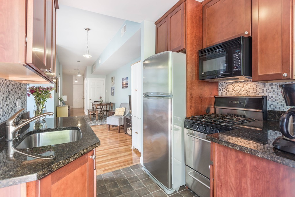 40 Rockview Street, Unit 4 Boston, MA 02130 - Photo 4 of 8 a kitchen with stainless steel appliances granite countertop a sink stove and refrigerator