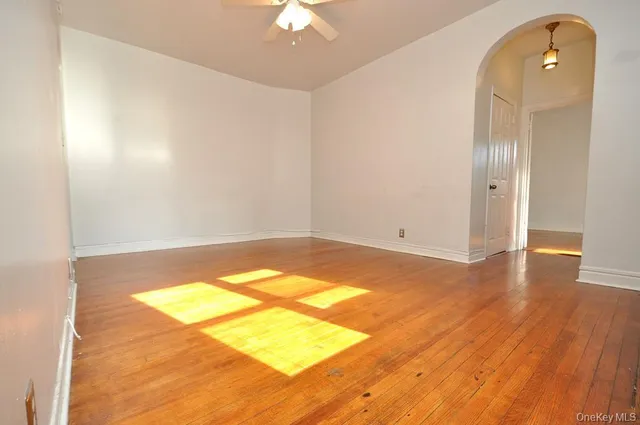 a view of a room with wooden floor and a ceiling fan