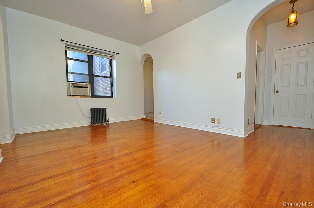 120 Stonelea Place, Unit 3M New Rochelle, NY 10801 - Photo 9 of 39 a view of empty room with wooden floor and fan