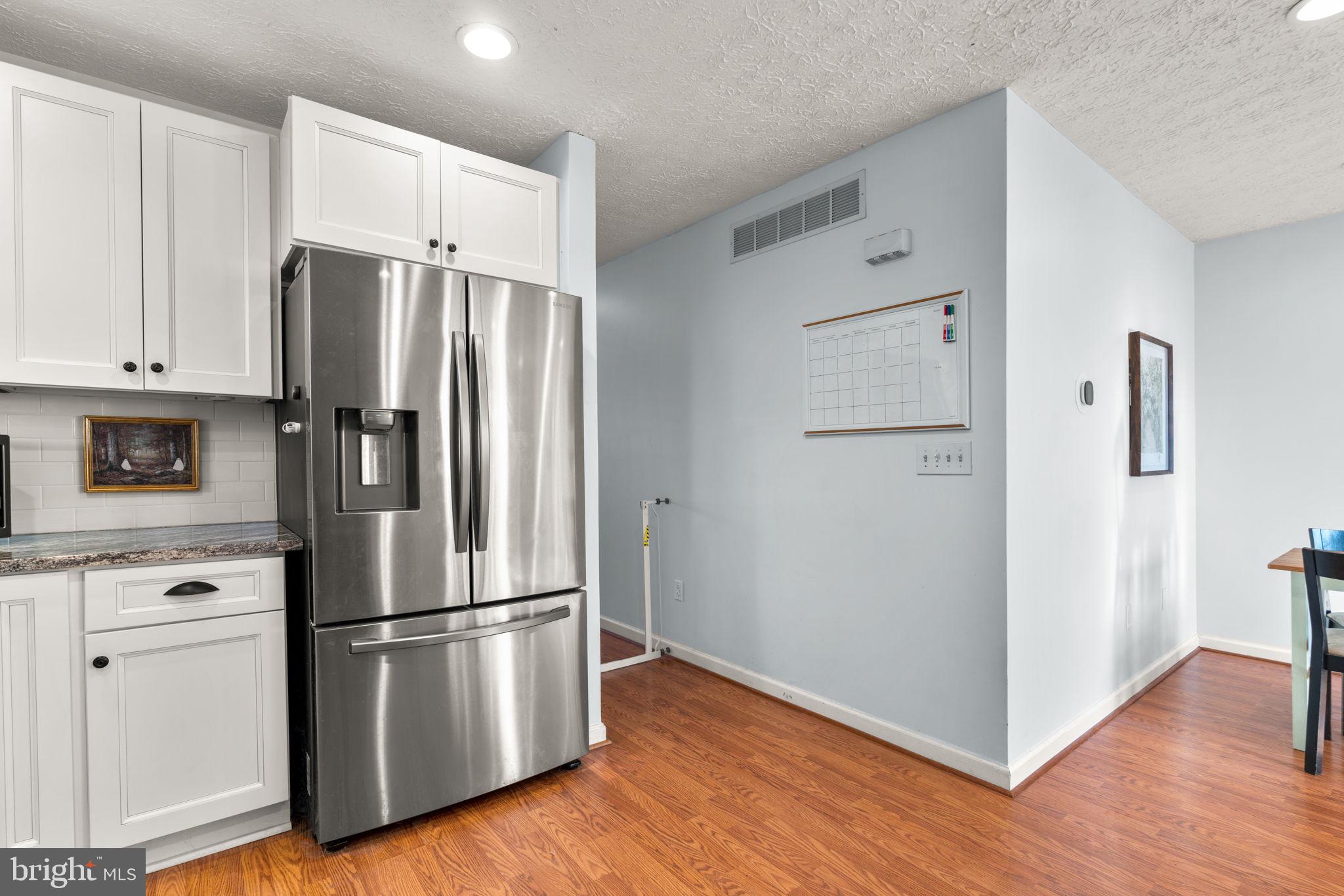 802 203rd Street Pasadena, MD 21122 - Photo 13 of 37 a kitchen with stainless steel appliances a refrigerator and a wooden floor