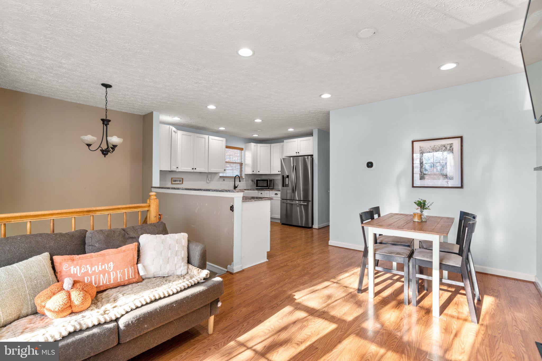 802 203rd Street Pasadena, MD 21122 - Photo 7 of 37 a living room with a couch and kitchen view with wooden floor