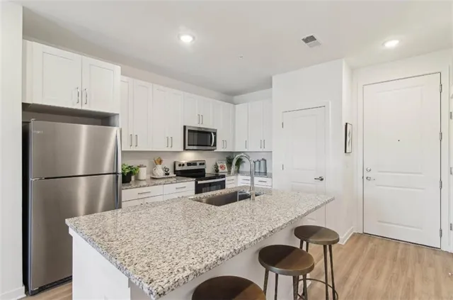 a kitchen with refrigerator and wooden floor