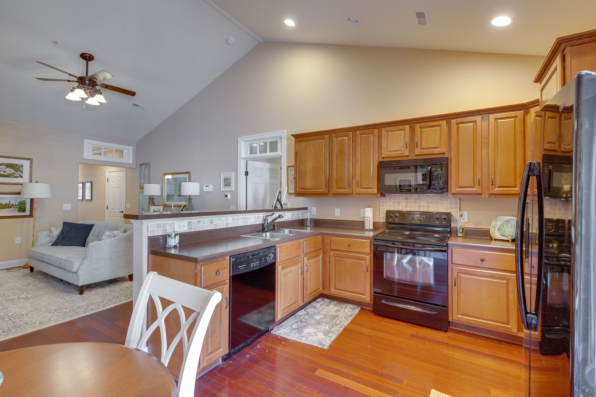102 Westview Drive Spring Hill, TN 37174 - Photo 11 of 27 a kitchen with stainless steel appliances granite countertop a stove top oven a sink dishwasher a dining table and chairs with wooden floor
