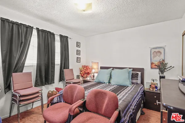 a bedroom with furniture and a large window
