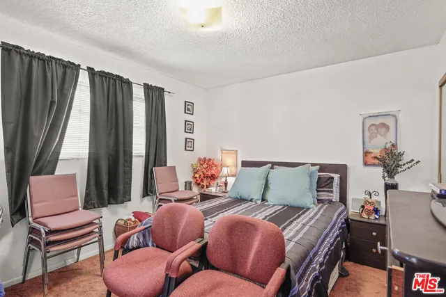 a bedroom with furniture and a large window