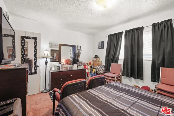 a bedroom with two beds and large windows
