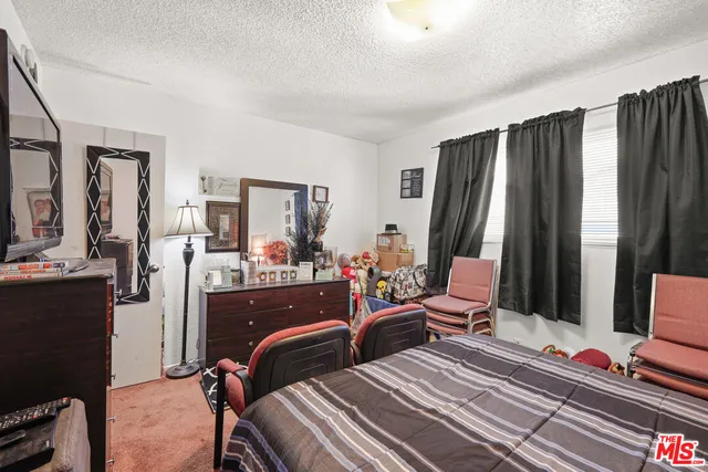 a bedroom with two beds and large windows