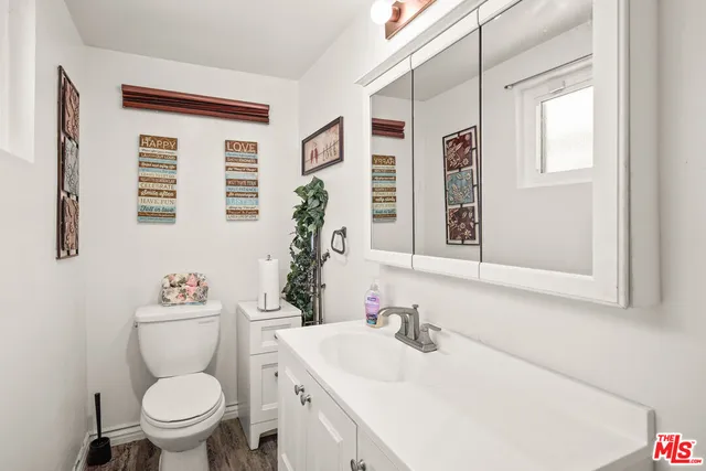 a bathroom with a sink toilet vanity and window