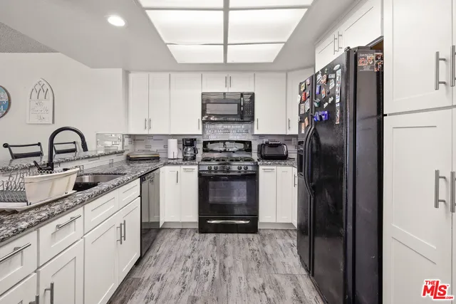 a kitchen with stainless steel appliances granite countertop a refrigerator and a stove