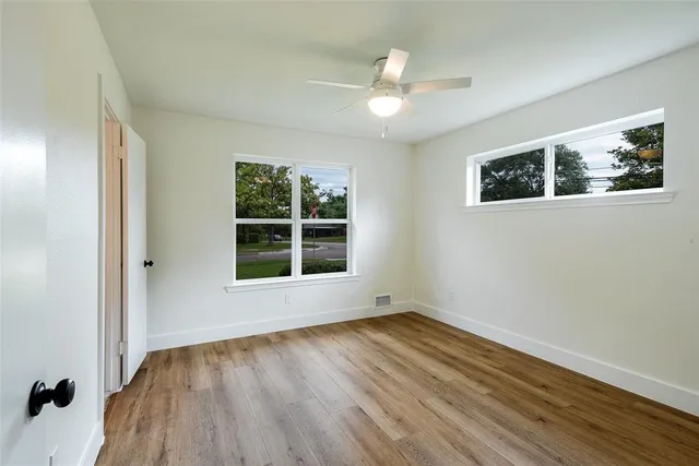 wooden floor in an empty room with a window