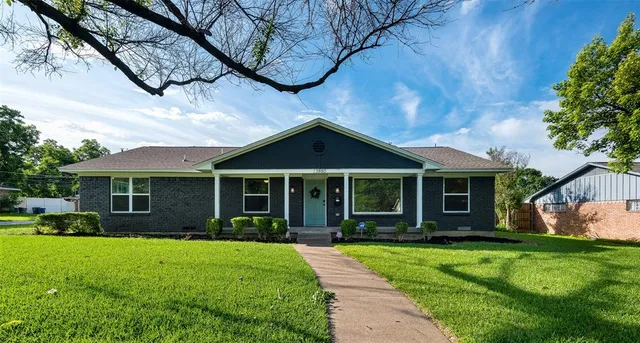 an empty room with wooden floor fireplace and windows