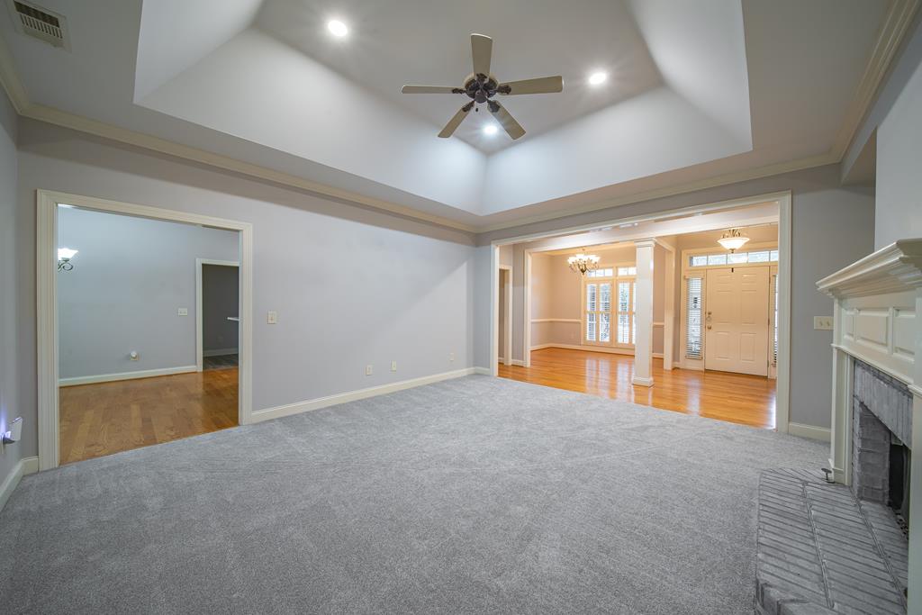 4571 Carnoustie Lane Columbus, GA 31909 - Photo 16 of 49 a view of an empty room with a fireplace and a chandelier