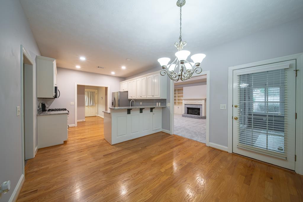 4571 Carnoustie Lane Columbus, GA 31909 - Photo 18 of 49 a open kitchen with kitchen island a stove a refrigerator a sink dishwasher with a dining table and chairs