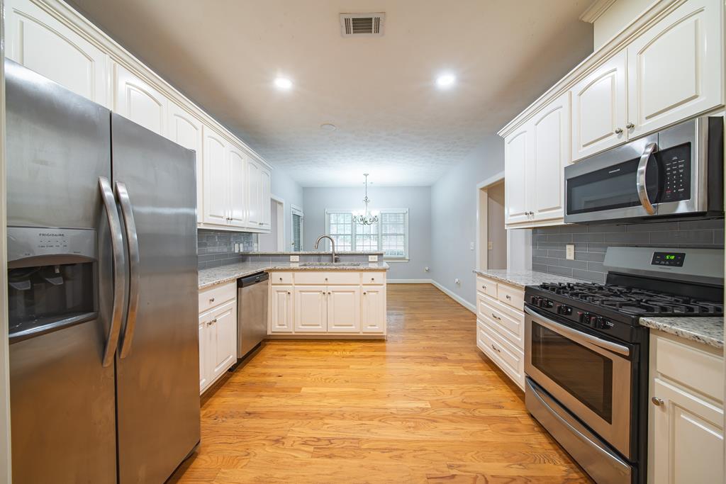4571 Carnoustie Lane Columbus, GA 31909 - Photo 24 of 49 a large kitchen with stainless steel appliances granite countertop a stove a sink and a refrigerator