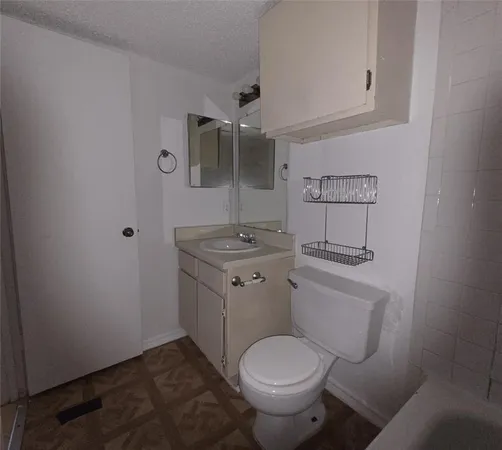 a bathroom with a granite countertop toilet sink and mirror