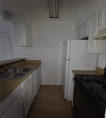 a kitchen with a refrigerator stove and cabinets
