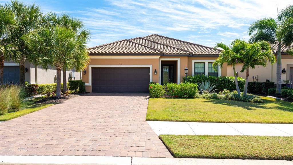4511 Terrazza Court Lakewood Ranch, FL 34211 - Photo 33 of 65 a front view of a house with a yard garage and outdoor seating