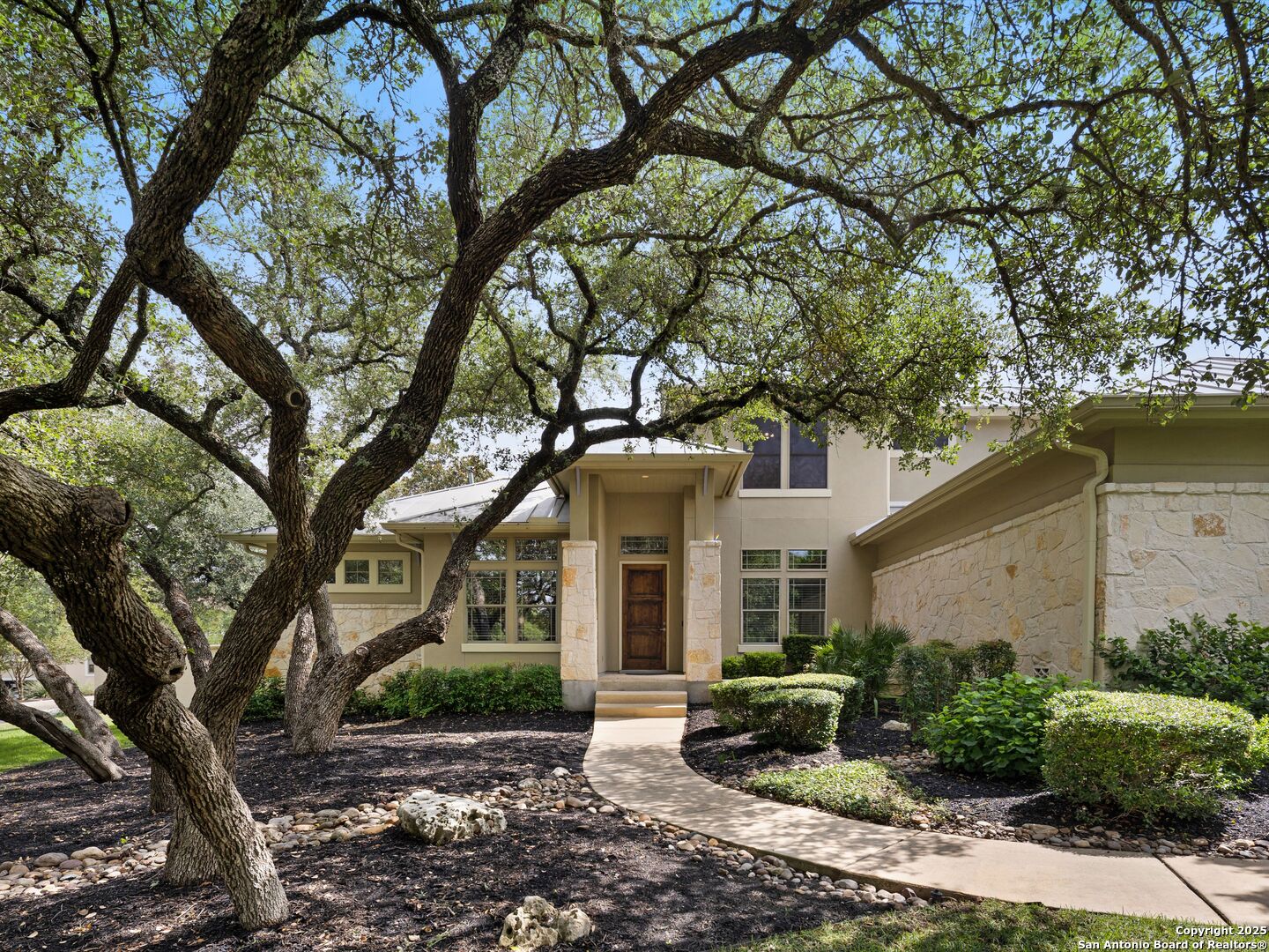 a view of a brick house with a large windows and large trees