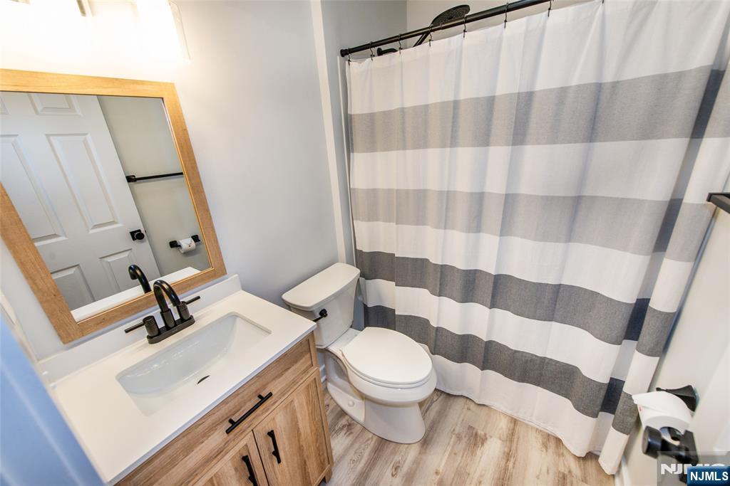 15 Village Way, Unit 5 Vernon, NJ 07462 - Photo 13 of 22 a bathroom with a sink a toilet a mirror and shower curtain
