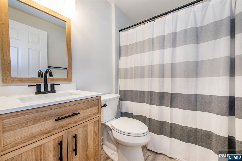 15 Village Way, Unit 5 Vernon, NJ 07462 - Photo 14 of 22 a bathroom with a sink a toilet a mirror and shower curtain