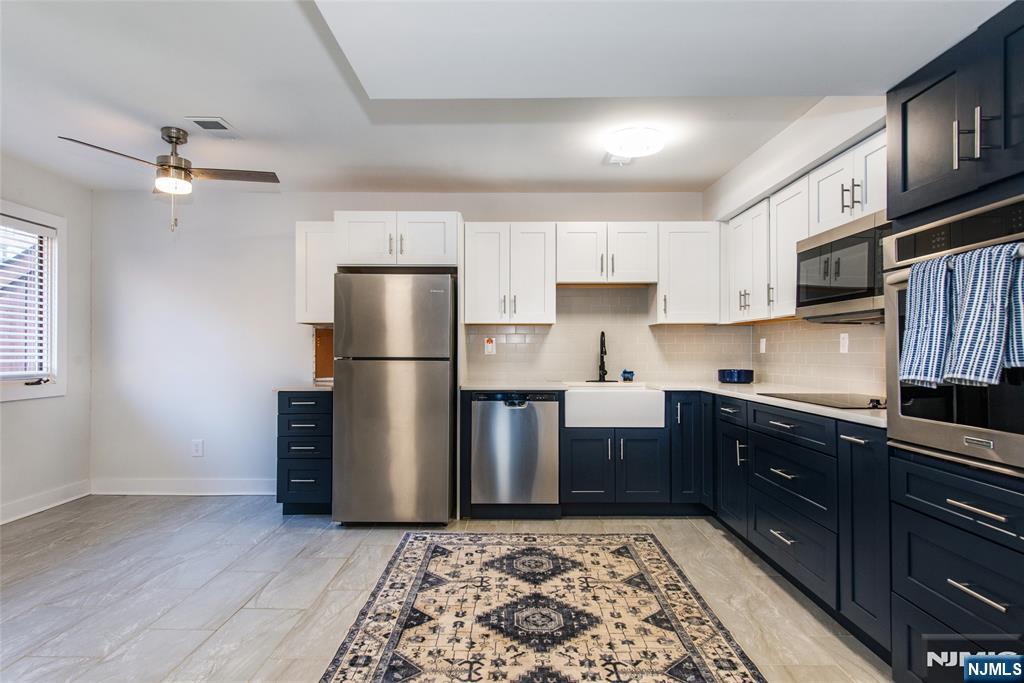 15 Village Way, Unit 5 Vernon, NJ 07462 - Photo 2 of 22 a kitchen with stainless steel appliances granite countertop a refrigerator a stove and a sink with wooden floor