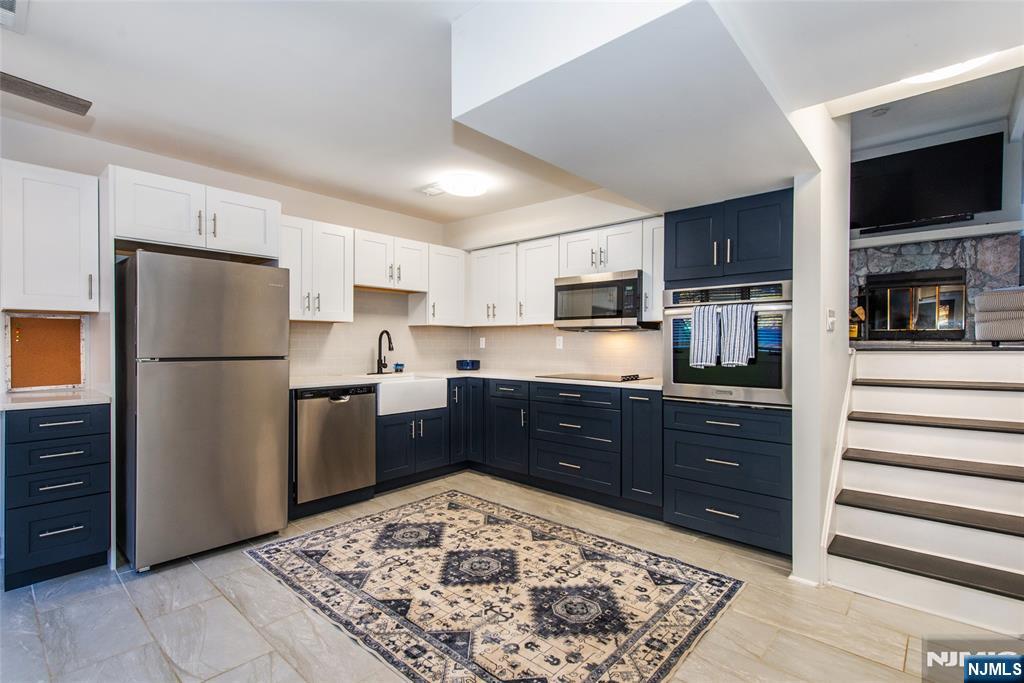 15 Village Way, Unit 5 Vernon, NJ 07462 - Photo 4 of 22 a kitchen with stainless steel appliances kitchen island granite countertop a refrigerator stove top oven and sink