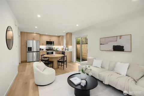 a dining room with wooden floor furniture and a kitchen view