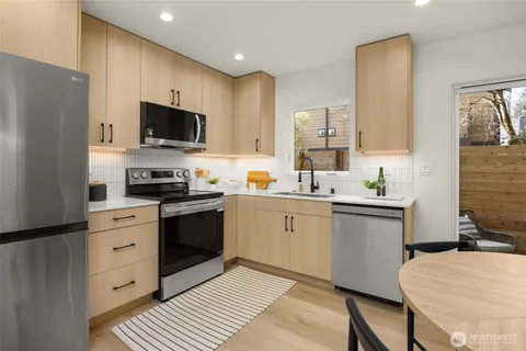 a kitchen with cabinets stainless steel appliances and sink
