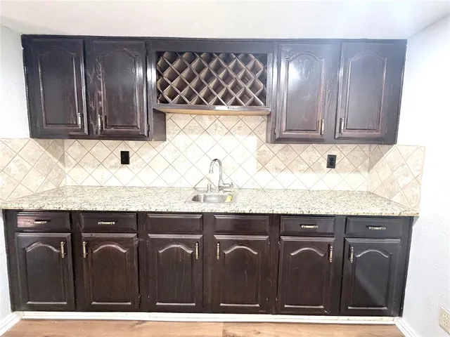 a view of kitchen with granite countertop wooden cabinets