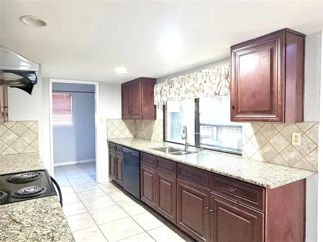 a kitchen with granite countertop a sink cabinets and window