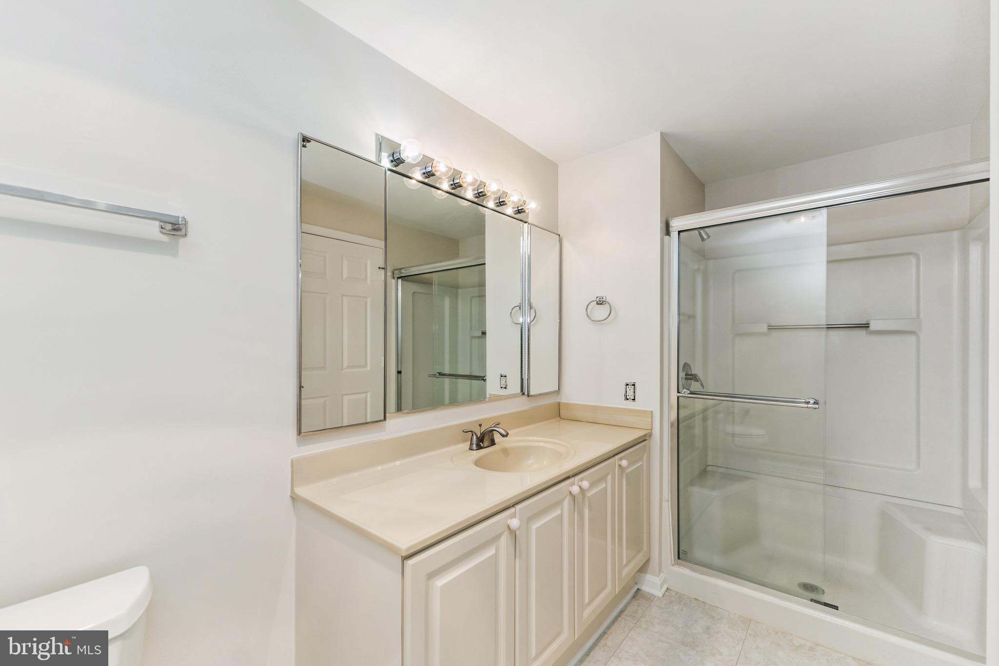 2900 North Leisure World Boulevard, Unit 209 Silver Spring, MD 20906 - Photo 22 of 24 a bathroom with a shower sink and mirror