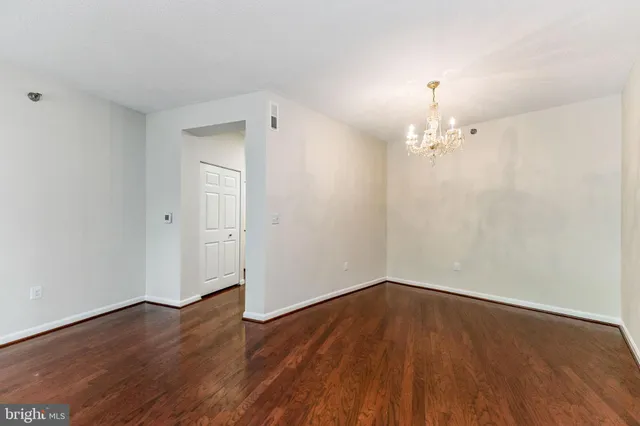 a view of a room with wooden floor and chandelier
