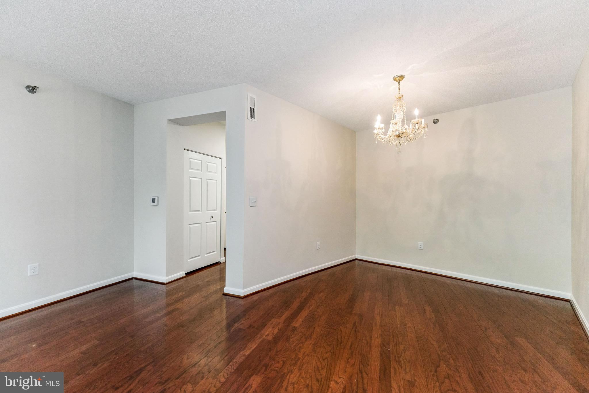 2900 North Leisure World Boulevard, Unit 209 Silver Spring, MD 20906 - Photo 5 of 24 a view of a room with wooden floor and chandelier
