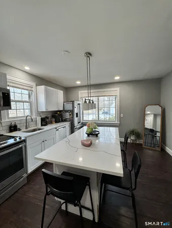 a kitchen with a dining table chairs and wooden floor