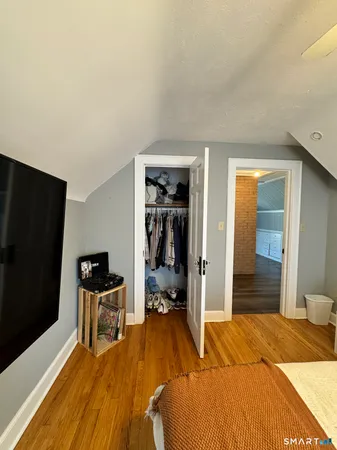 a bedroom with a bed and a flat tv screen on wall