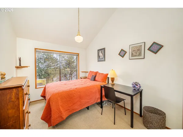 a bed sitting in a bedroom next to a window