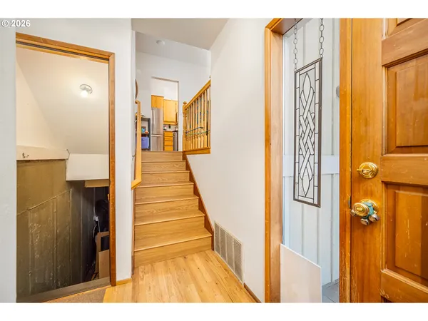 a view of a hallway with wooden floor and staircase