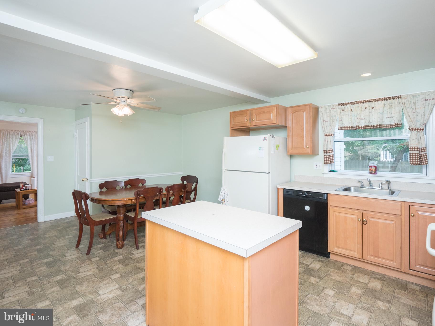 9431 Guilford Road Columbia, MD 21046 - Photo 5 of 28 a kitchen with a stove a sink a dining table and chairs