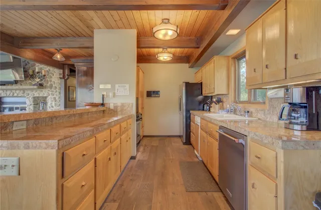 a large kitchen with stainless steel appliances kitchen island granite countertop a sink and cabinets