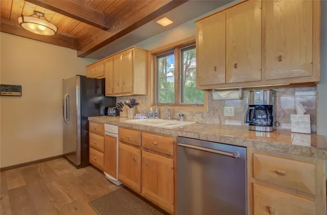 a kitchen with stainless steel appliances granite countertop a sink window and cabinets