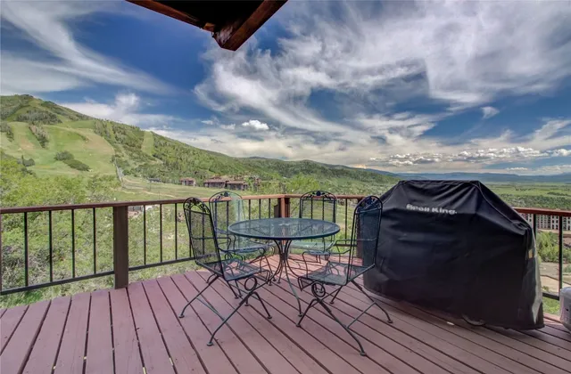 a view of a balcony with wooden floor and outdoor seating