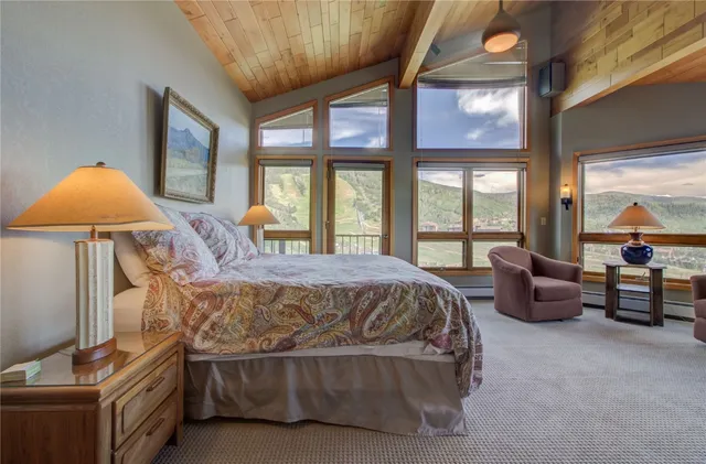 a spacious bedroom with a bed and a chandelier