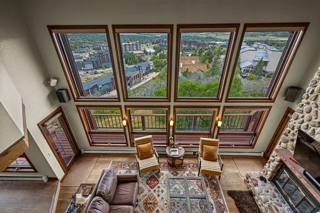 a living room with a large window and a bed