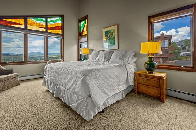 a spacious bedroom with a bed and glass window