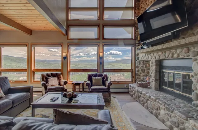a living room with furniture large windows and a fireplace